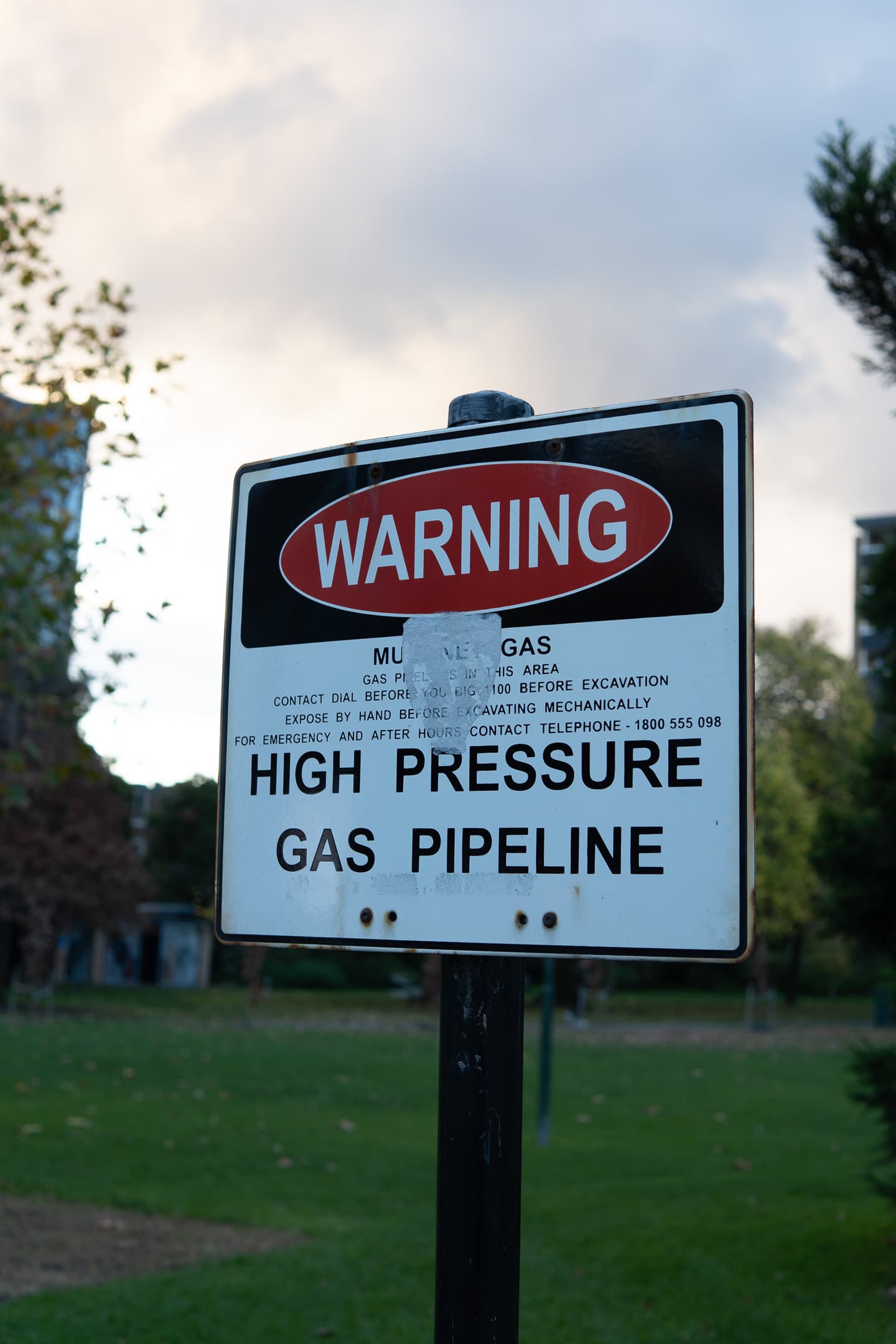 A warning sign about a high-pressure gas pipeline, with additional safety and emergency contact information