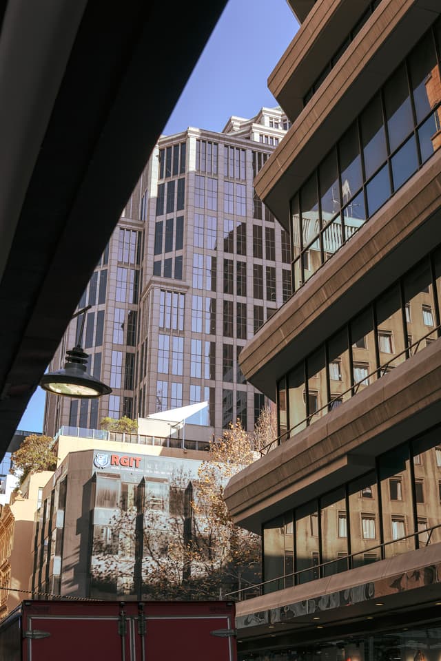 A cityscape featuring modern buildings with a mix of architectural styles, under a clear blue sky