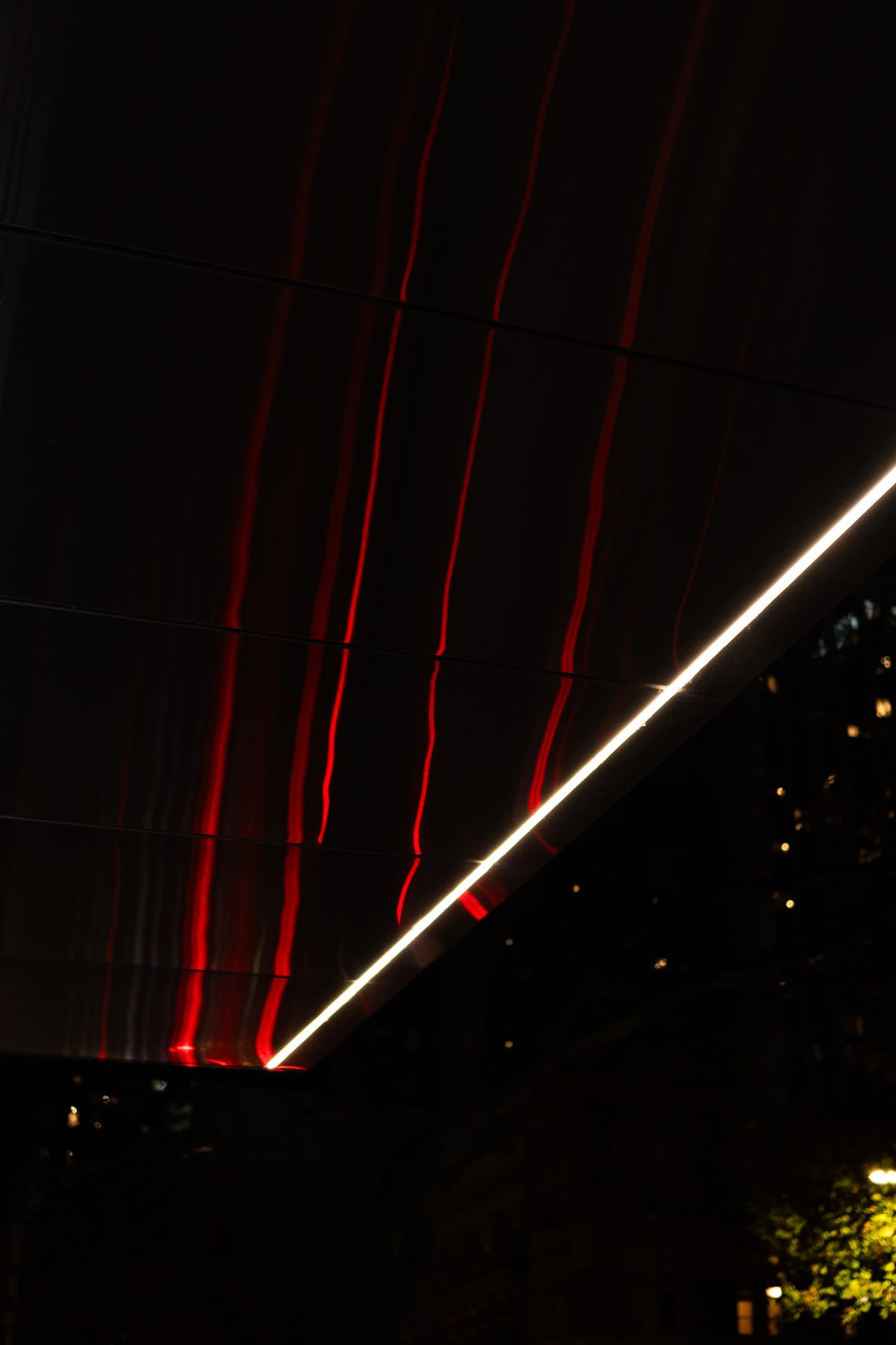 Red and white light streaks against a dark background, possibly a long exposure of moving lights at night