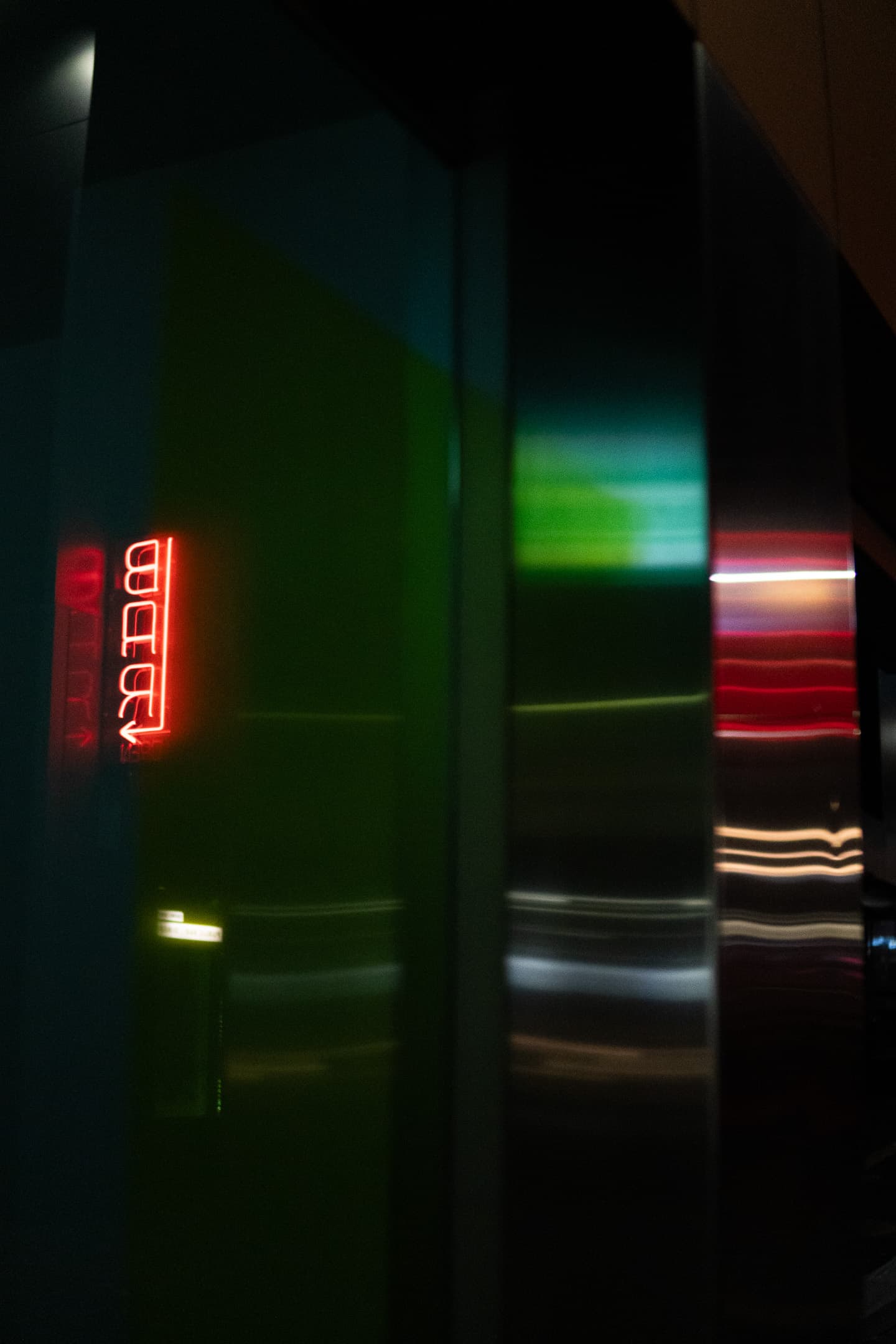 A dark scene with colorful light streaks, possibly from a moving vehicle or lights, with a red digital clock display reading 00:00 visible in the background