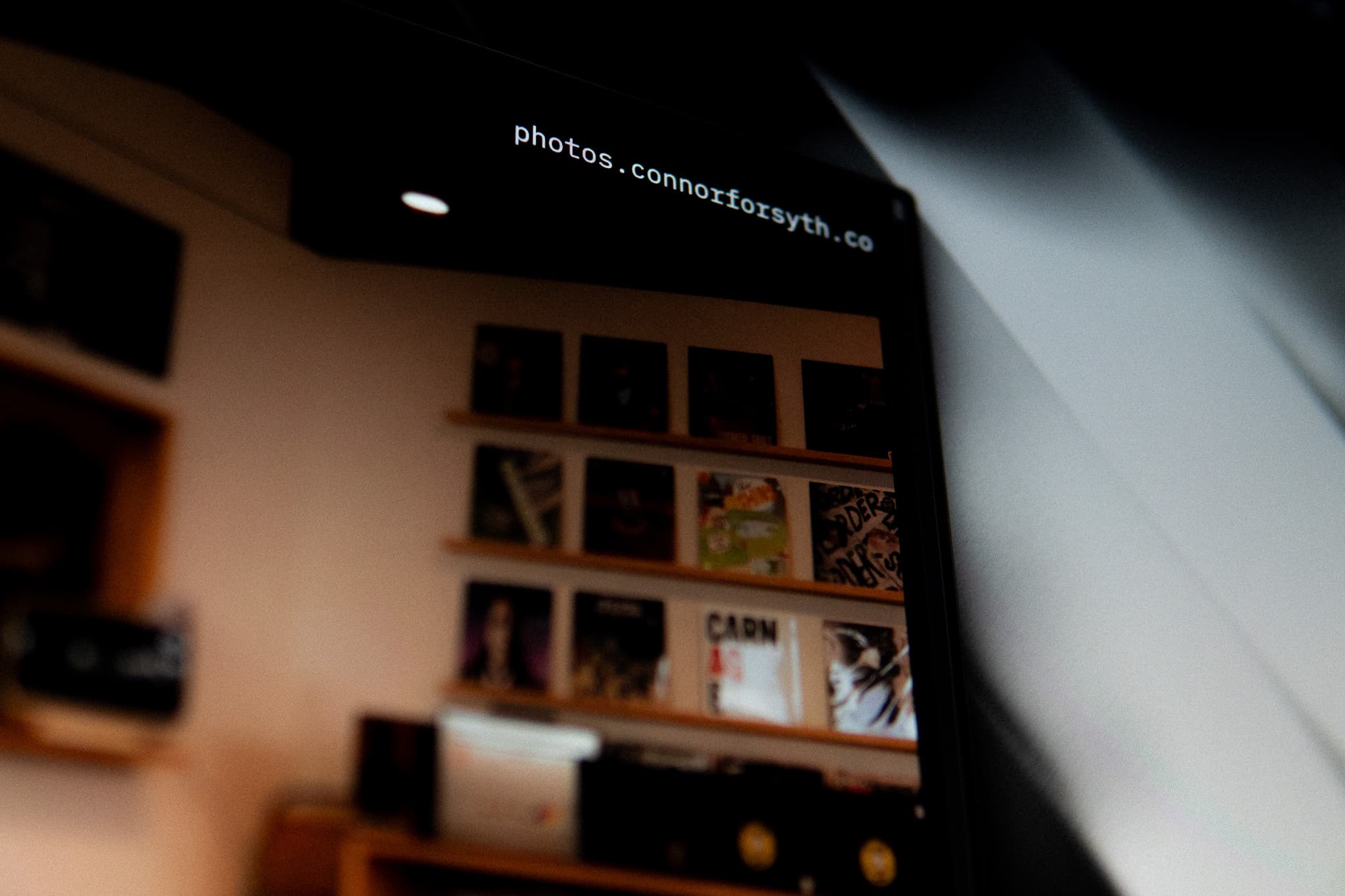 A blurred interior scene with a shelf holding various items, including books or records, under a dark ceiling with visible text